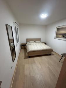 a bedroom with a bed and a wooden floor at Maison Relax Spa & tranquillité in Auberchicourt