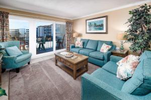 ein Wohnzimmer mit zwei blauen Sofas und einem Tisch in der Unterkunft Sea Oats 509 Gulf front condo in Fort Walton Beach