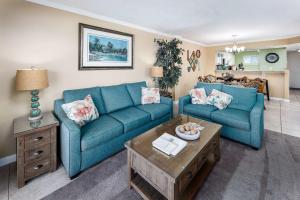 ein Wohnzimmer mit zwei blauen Sofas und einem Tisch in der Unterkunft Sea Oats 509 Gulf front condo in Fort Walton Beach