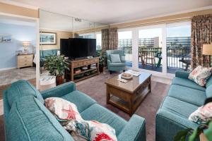 ein Wohnzimmer mit zwei blauen Sofas und einem Fernseher in der Unterkunft Sea Oats 509 Gulf front condo in Fort Walton Beach