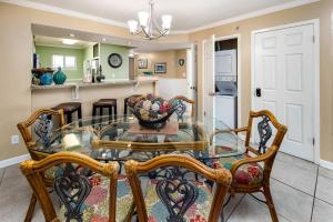 ein Esszimmer mit Glastisch und Stühlen in der Unterkunft Sea Oats 509 Gulf front condo in Fort Walton Beach + 34 Fotos