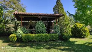 a gazebo in a yard with bushes and trees at Lea's Studio in Kourouta