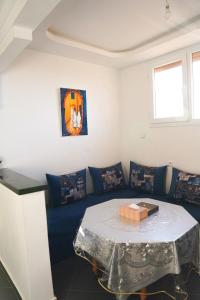 Una sala de estar con un sofá azul con una mesa. en Studio stay, comfort local vibes in Tiznit, en Tiznit