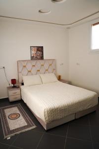 1 dormitorio con 1 cama blanca grande y 1 alfombra en Studio stay, comfort local vibes in Tiznit, en Tiznit