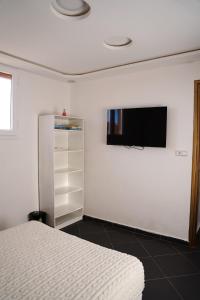 Un dormitorio con una cama y un televisor en la pared. en Studio stay, comfort local vibes in Tiznit, en Tiznit