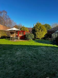 un patio con mesa y sombrilla en Big Group Bungalow, Sleeps 9, Perfect for Families, en Sturminster Newton