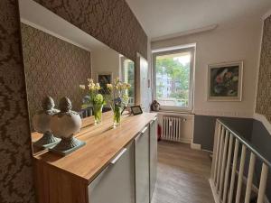 a room with a counter with vases and flowers on it at Hotel Am Ehrenhof in Düsseldorf