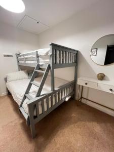 Un dormitorio con dos literas y un espejo. en Big Group Bungalow, Sleeps 9, Perfect for Families, en Sturminster Newton 111 fotos más
