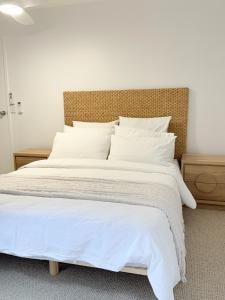 a large white bed with white sheets and pillows at 2Bdr Beachfront Apartment - First Bay Coolum in Coolum Beach +14 photos