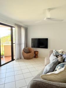 een woonkamer met een bank en een flatscreen-tv bij 2Bdr Beachfront Apartment - First Bay Coolum in Coolum Beach +14 foto's
