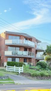 an apartment building with a white fence in front of it at 2Bdr Beachfront Apartment - First Bay Coolum in Coolum Beach