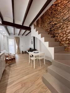 a room with a stone wall and a table and stairs at Restored house near Valencia in Simat de Valldigna