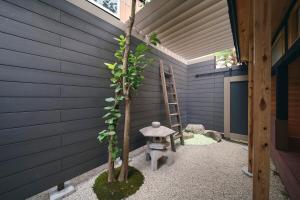 un piccolo giardino con una scala accanto a un albero di 御宿 凪ぐ Takayama a Wada