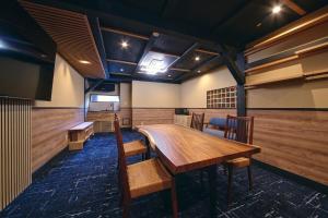una sala da pranzo con tavolo e sedie in legno di 御宿 凪ぐ Takayama a Wada