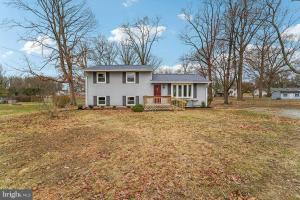una casa blanca con una puerta roja en un patio en Gambrills Modern Retreat near Annapolis & Ft Meade, en Gambrills