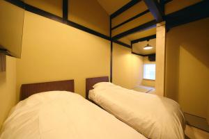 due letti in una stanza con pareti gialle di 御宿 凪ぐ Takayama a Wada Altre 4 foto