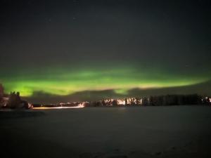 an aurora in the sky over a lake at night at Aurora House in Karungi