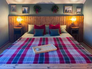 a bed with a plaid blanket and a tray on it at Aurora House in Karungi