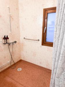 a bathroom with a shower curtain and a window at Aurora House in Karungi +8 photos
