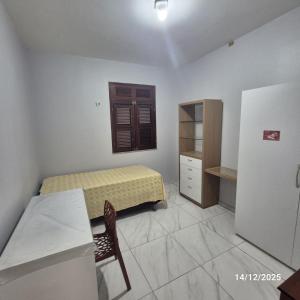 Casa de condomínio privativo في فورتاليزا: غرفة نوم صغيرة بسرير وطاولة وكرسي