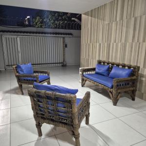 Casa de condomínio privativo في فورتاليزا: كرسيان الخوص مع الوسائد الزرقاء في الغرفة