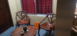 two chairs and a table in front of a window at Athula Beach Front Hotel Hikkaduwa in Hikkaduwa