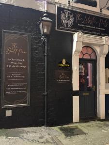 ein schwarzes Gebäude mit einer schwarzen Tür und einer Straßenlaterne in der Unterkunft The Lobster Pots - Bawtry in Bawtry