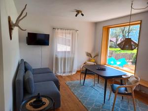 Alpen Lodge in Osterhofen - Berge, Ruhe & Natur في بايريشزيل: غرفة معيشة مع أريكة زرقاء وطاولة