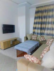 a living room with a couch and a flat screen tv at Le paradis in Martil