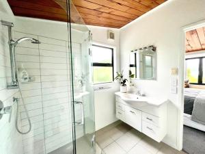 ein Badezimmer mit Dusche, Waschbecken und Spiegel in der Unterkunft Iconic Taupō Views in Taupo + 18 Fotos