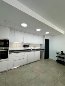 an empty kitchen with white cabinets and a sink at OCEAN APARTAMENT !! 1ª Línea del Mar, piscina, parking, wifi in Mojácar