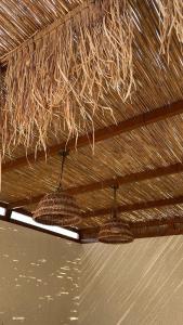 Ash Shuqayqبريز الشقيق的两盏灯悬挂在茅草屋顶上。