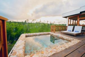 a pool on the deck of a house with two chairs at Hidden Valley Wilderness Lodge in Blancaneau