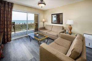 un soggiorno con un divano e un tavolo di Summerlin 102 Spacious Gulf front condo a Fort Walton Beach