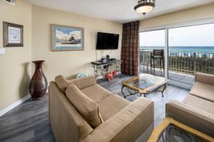un soggiorno con un divano e una televisione di Summerlin 102 Spacious Gulf front condo a Fort Walton Beach