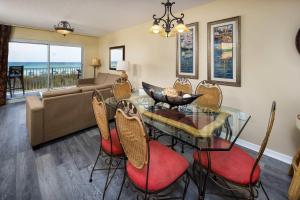 un soggiorno con tavolo e sedie in vetro di Summerlin 102 Spacious Gulf front condo a Fort Walton Beach