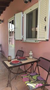 a table and chairs in a room with windows at Lea's Apartment in Kourouta