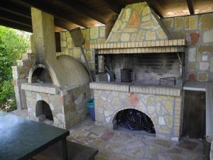 a large stone oven with a table in front of it at Lea's Apartment in Kourouta