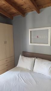 a bedroom with a white bed with a sign on the wall at Lea's Apartment in Kourouta