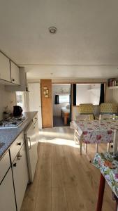 a kitchen and living room with a table and a stove at Mobile home toutes saisons in Beauzac