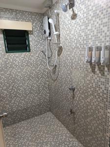 una ducha en un baño con una pared de azulejos en LG Palms, en Sigatoka