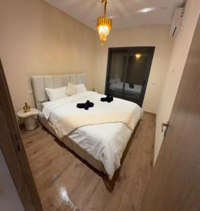 マルティルにあるAppartement haut standing 2 chambres piscine Martilのベッドルーム1室(黒い靴のベッド1台付)