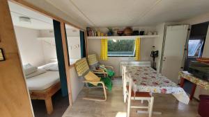 una pequeña habitación con una mesa y una cama en Mobile home toutes saisons, en Beauzac 28 fotos más