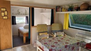 Habitación pequeña con mesa y sillas en caravana en Mobile home toutes saisons, en Beauzac