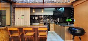 a kitchen with a large wooden table and chairs at Bamboo Búzios Hostel in Búzios