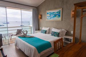 Un dormitorio con una cama con vista al mar. en Bamboo Búzios Hostel, en Búzios 222 fotos más