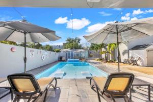 Una piscina con sillas y sombrillas al lado de una piscina. en AQUA Ville Moderna - Serene 16BR Coastal Haven Villa with Pool, en Dorado
