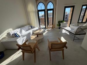 a living room with a couch and chairs and windows at EYZ Lofts By EYZ Holiday Homes in Batroûn
