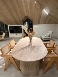 a white table with chairs and a vase with flowers at EYZ Lofts By EYZ Holiday Homes in Batroûn