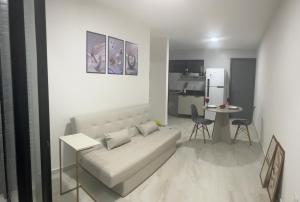 a living room with a couch and a table and a kitchen at Belize flat praia de Intermares in Cabedelo